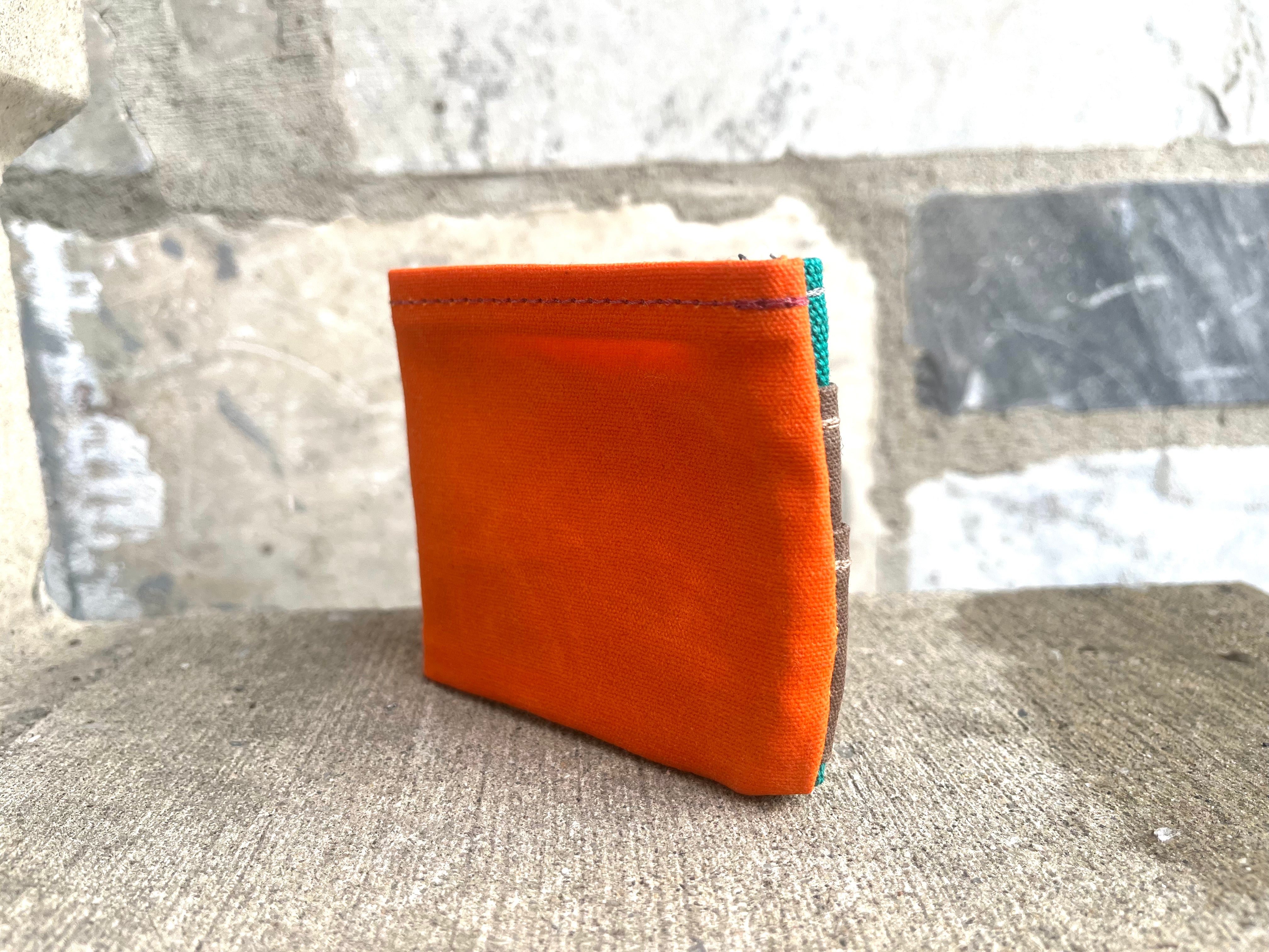 Orange wallet on a textured surface